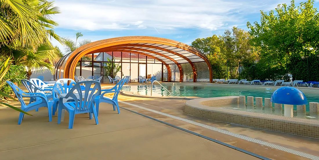 Verwarmd overdekt bad onder het houten glazen dak, met terras en peuterbad met waterpaddenstoel, camping l'Étoile d'Or
