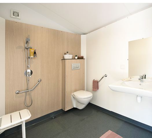 Salle d'eau adaptée du cottage PMR : douche de plain-pied, siège et barres d'appui